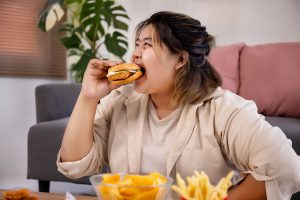 ilustrasi seorang wanita dengan kebiasaan konsumsi junk food